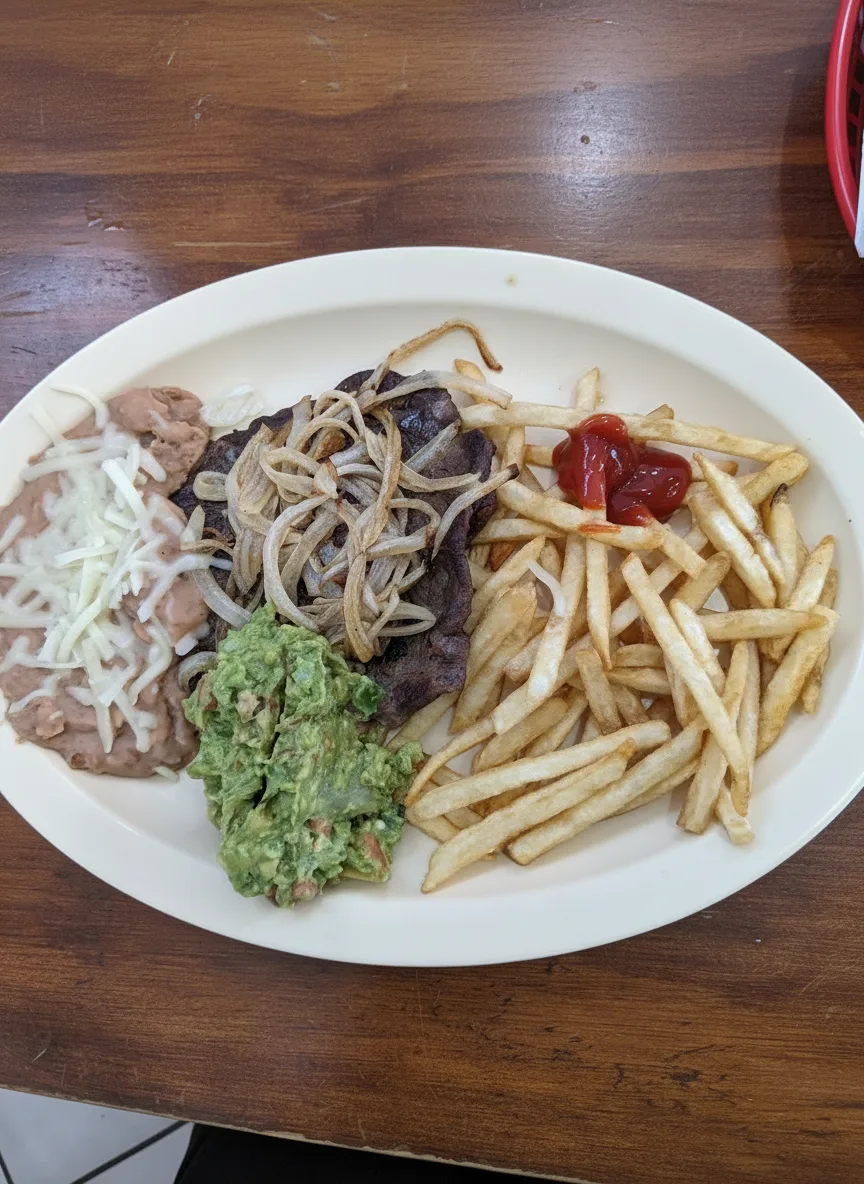 Carne asada with grilled onions, guacamole, beans and fries
